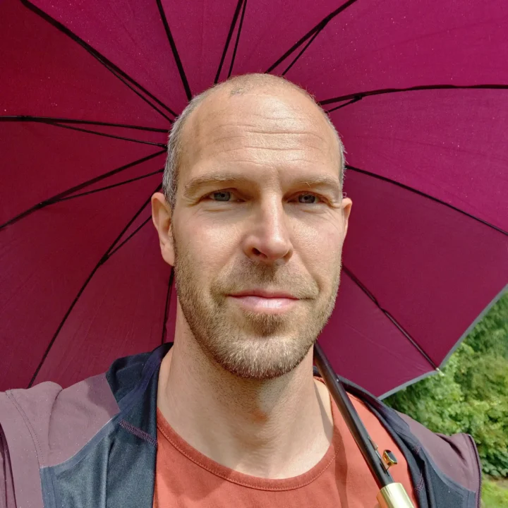 Portrait Christian Zoch, Begleiter für verkörperte Bewusstseinsarbeit, mit Regenschirm